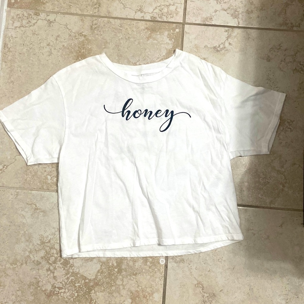 White crop top with the word honey on the front and a proverb on the back.